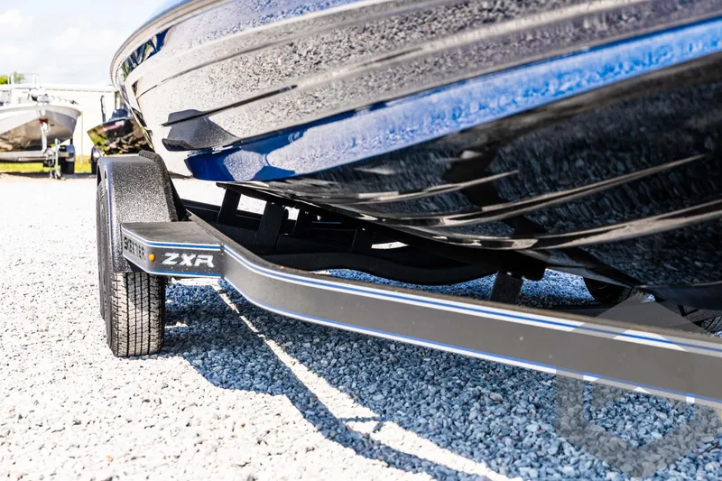 Slide: The Image of 2025 Skeeter ZXR 21 boat on trailer, close-up view, parked on gravel. - 10