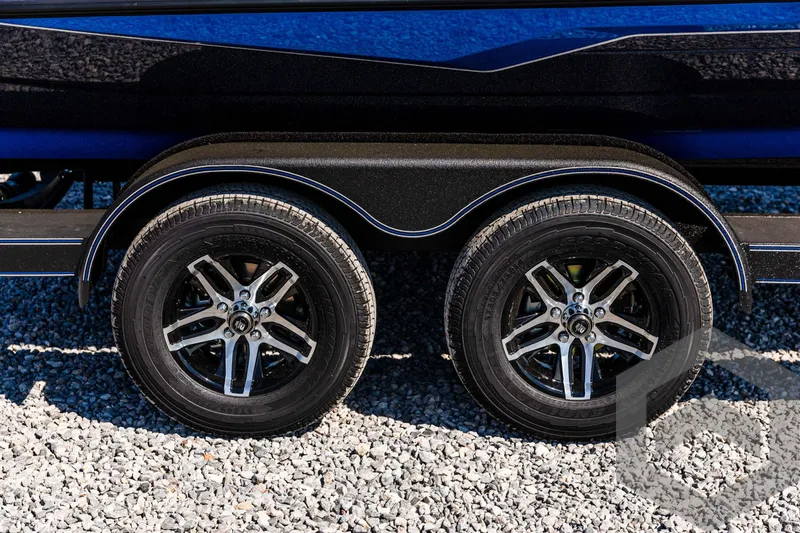 Slide: The Image of 2025 Skeeter ZXR 21 trailer wheels on gravel surface. - 12