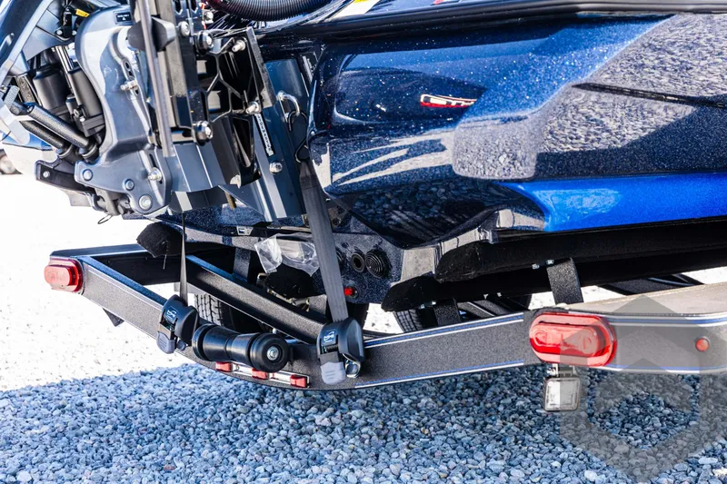 Slide: The Image of 2025 Skeeter ZXR 21 boat trailer hitch and motor detail on gravel. - 14