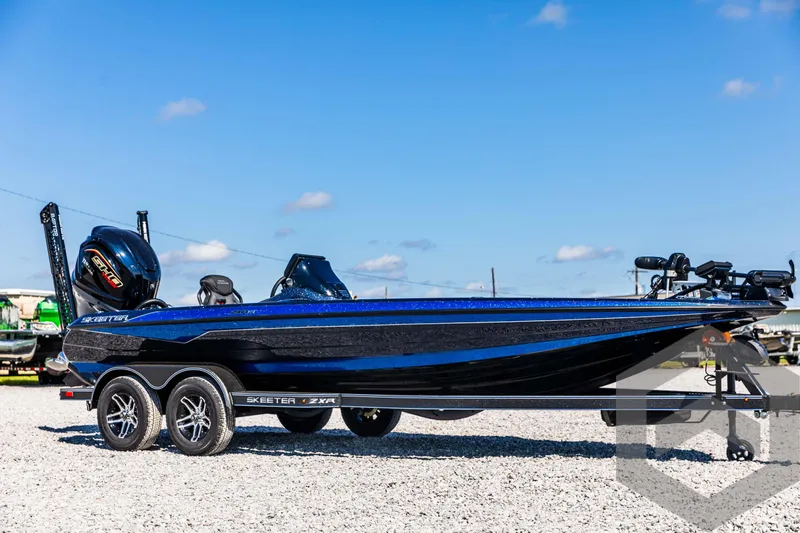 Slide: The Image of 2025 Skeeter ZXR 21 boat, sleek design, parked on gravel, clear blue sky background. - 3