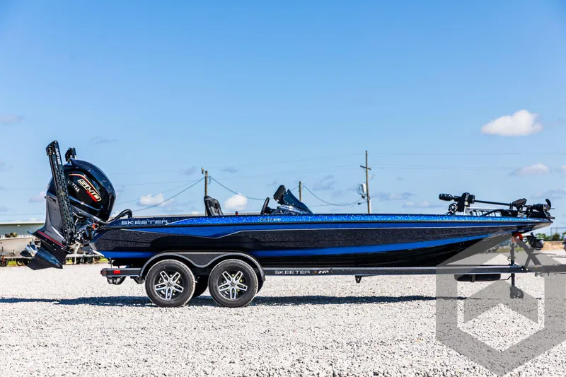 Slide: The Image of 2025 Skeeter ZXR 21 boat on trailer, blue and black design, outdoor setting. - 4
