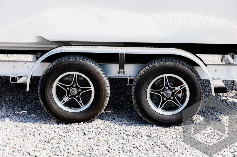Slide: The Image of Trailer wheels for 2025 Tidewater 2300 Carolina Bay boat on gravel. - 21