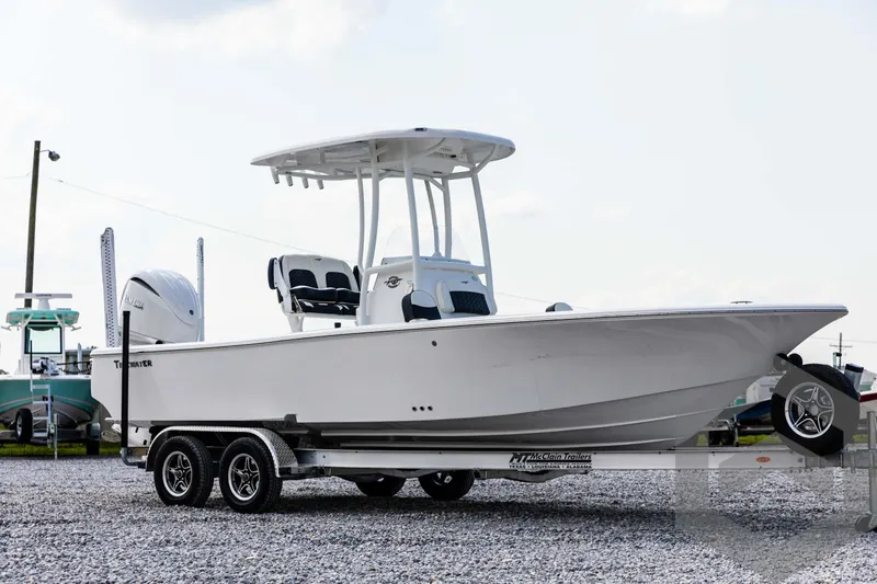 Slide: The Image of 2025 Tidewater 2300 Carolina Bay boat on a trailer in a gravel lot. - 3