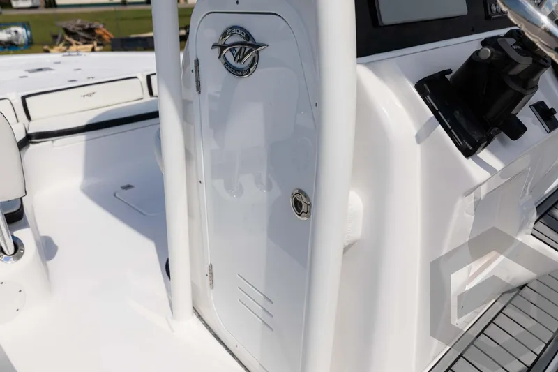 Slide: The Image of 2025 Tidewater 2300 Carolina Bay boat console with storage compartment and steering controls. - 30