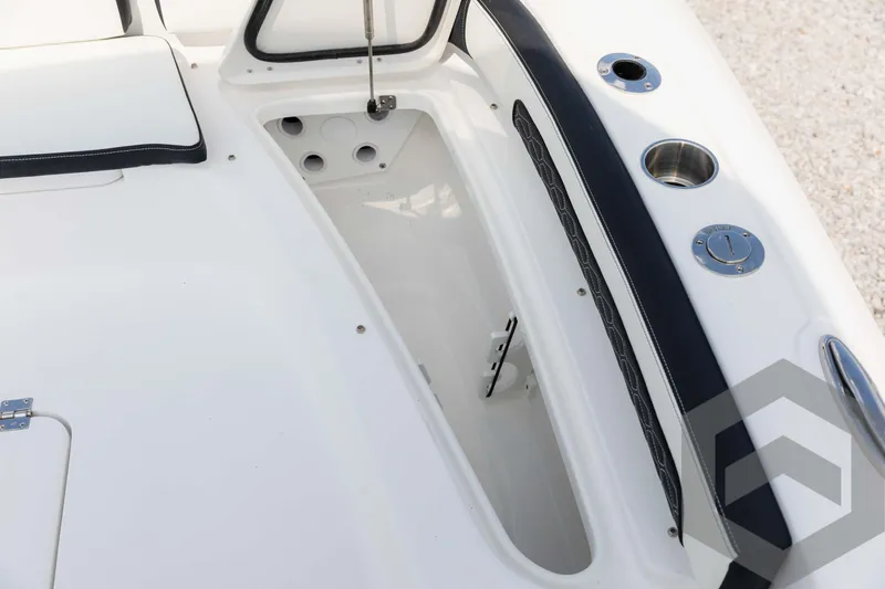 Slide: The Image of 2025 Tidewater 2300 Carolina Bay boat interior with storage compartment and cup holders. - 37