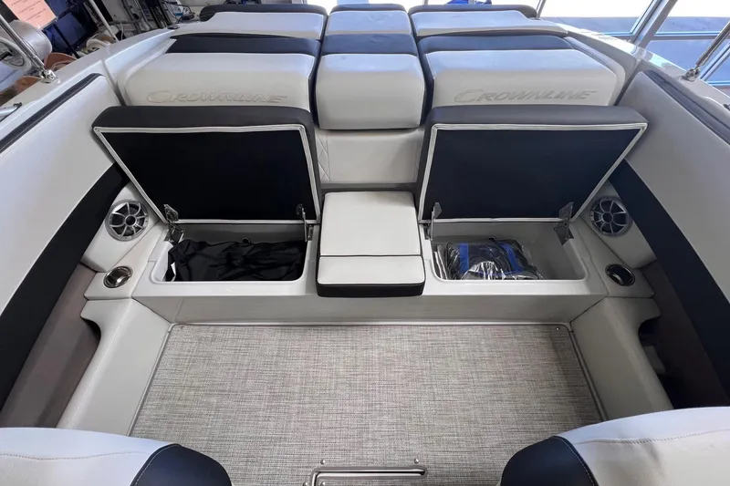 Slide: The Image of 2024 Crownline 210SS boat interior with open storage compartments and cushioned seating. - 11