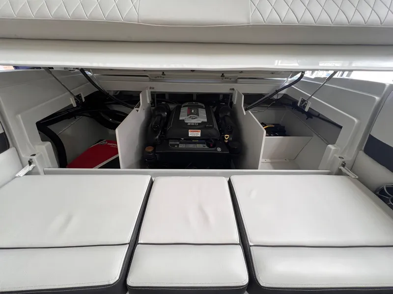 Slide: The Image of 2024 Crownline 210SS boat engine compartment with cushioned seating. - 7