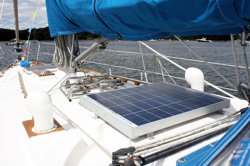 Slide: The Image of 1978 Tartan 37 sailboat with solar panel on deck, blue sail cover, docked by water. - 14