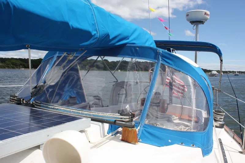 Slide: The Image of 1978 Tartan 37 sailboat with blue canopy, solar panel, and American flag on a sunny day. - 15