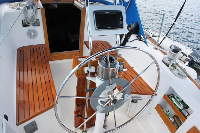 Slide: The Image of Cockpit of a 1978 Tartan 37 sailboat with wooden seating and steering wheel. - 16