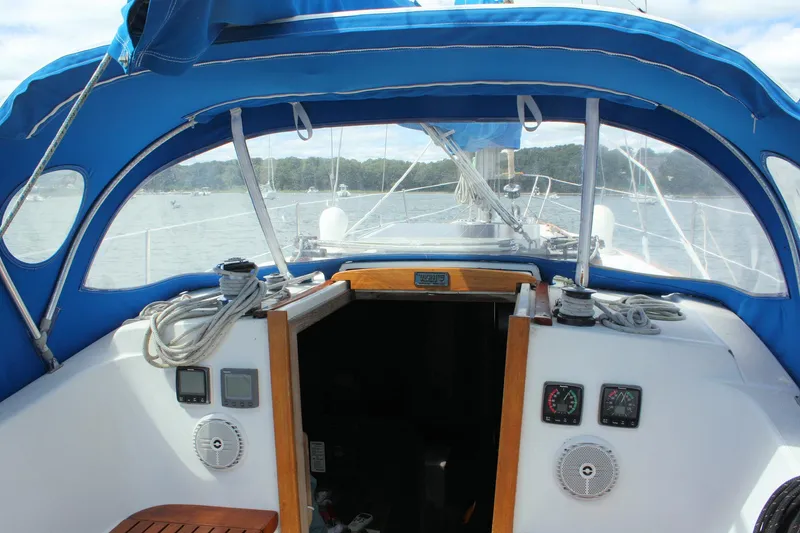 Slide: The Image of Cockpit of a 1978 Tartan 37 sailboat with blue canopy and nautical instruments. - 17