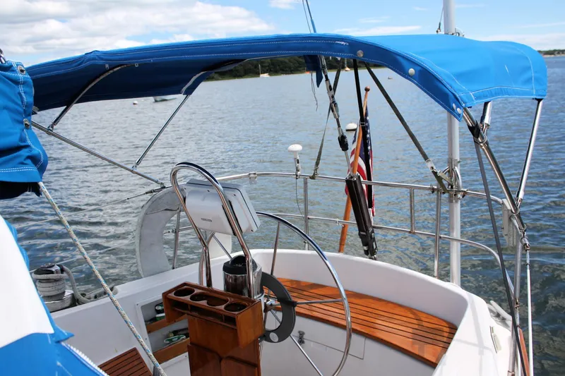Slide: The Image of 1978 Tartan 37 sailboat cockpit with blue canopy on calm water. - 18