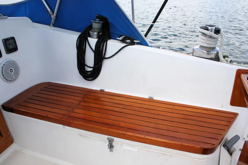 Slide: The Image of Wooden bench on 1978 Tartan 37 sailboat deck, with coiled rope and winch nearby. - 19