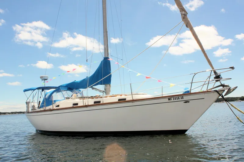 Slide: The Image of 1978 Tartan 37 sailboat with blue canopy on calm water under a clear sky. - 2