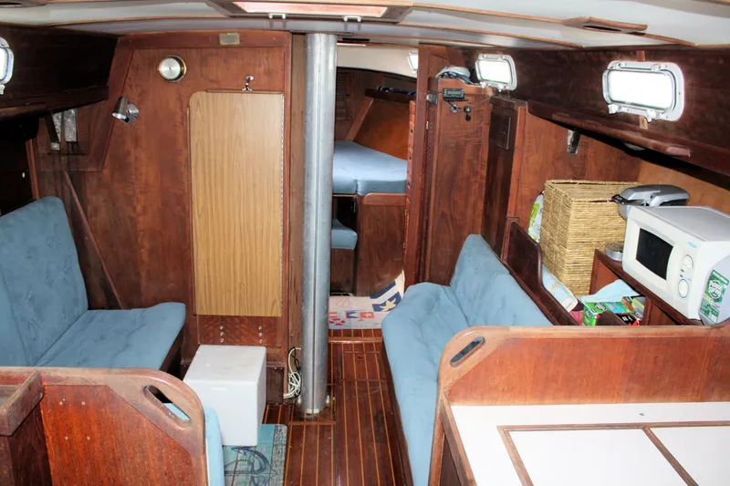 Slide: The Image of Interior of a 1978 Tartan 37 sailboat with wood paneling and blue seating. - 25