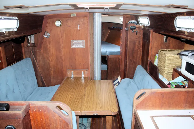 Slide: The Image of 1978 Tartan 37 sailboat interior with wooden furnishings and cozy seating area. - 27