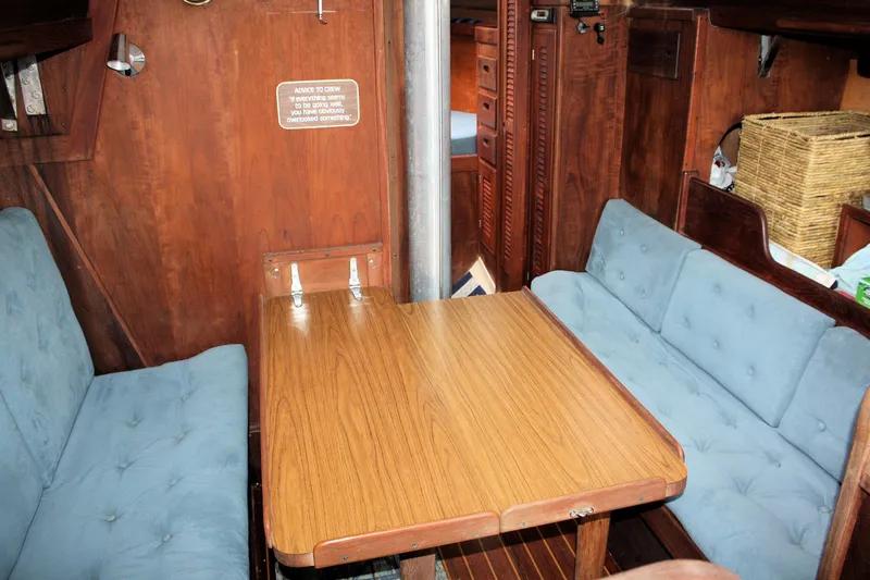 Slide: The Image of Interior of 1978 Tartan 37 sailboat with wooden table and blue cushioned seating. - 28