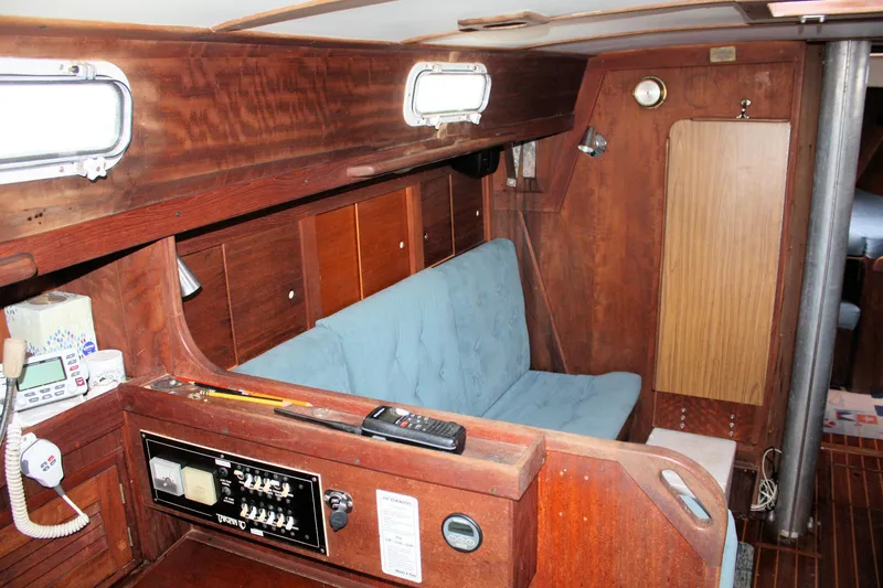 Slide: The Image of Interior of a 1978 Tartan 37 sailboat with wood paneling and blue seating. - 29