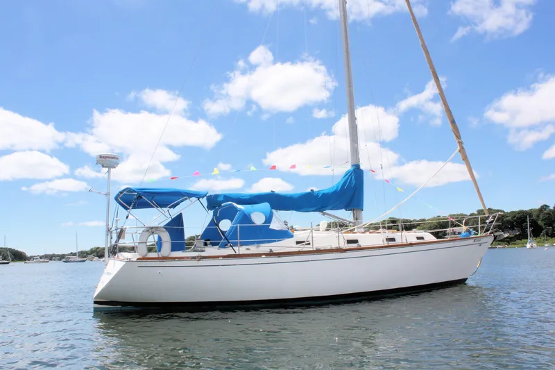 Slide: The Image of 1978 Tartan 37 sailboat on calm water under a clear blue sky. - 3