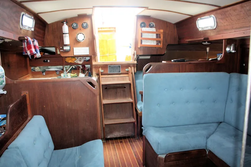 Slide: The Image of Interior of a 1978 Tartan 37 sailboat with blue seating and wooden finishes. - 31