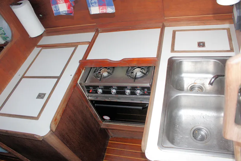 Slide: The Image of 1978 Tartan 37 yacht kitchen with stove, double sink, and wooden cabinetry. - 32