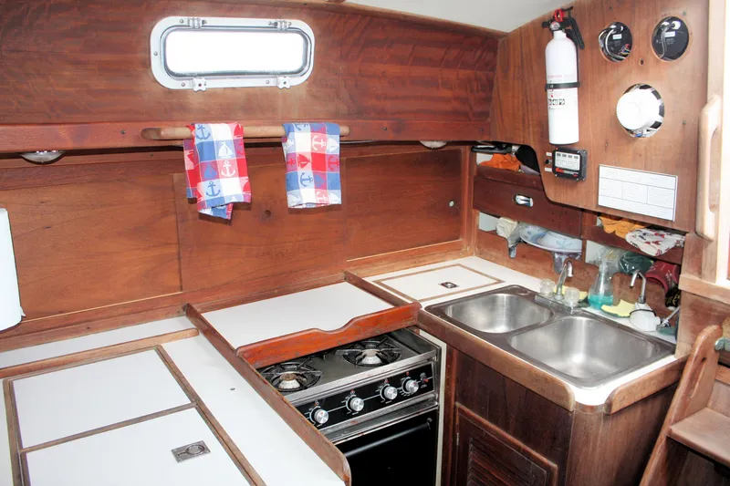 Slide: The Image of 1978 Tartan 37 yacht kitchen with stove, sink, and wooden cabinetry. - 33