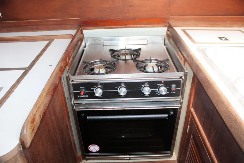 Slide: The Image of 1978 Tartan 37 yacht kitchen with a three-burner stove and oven. - 35