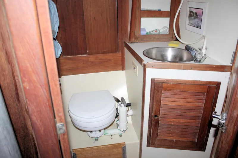 Slide: The Image of 1978 Tartan 37 yacht bathroom with wooden cabinetry, sink, and marine toilet. - 37