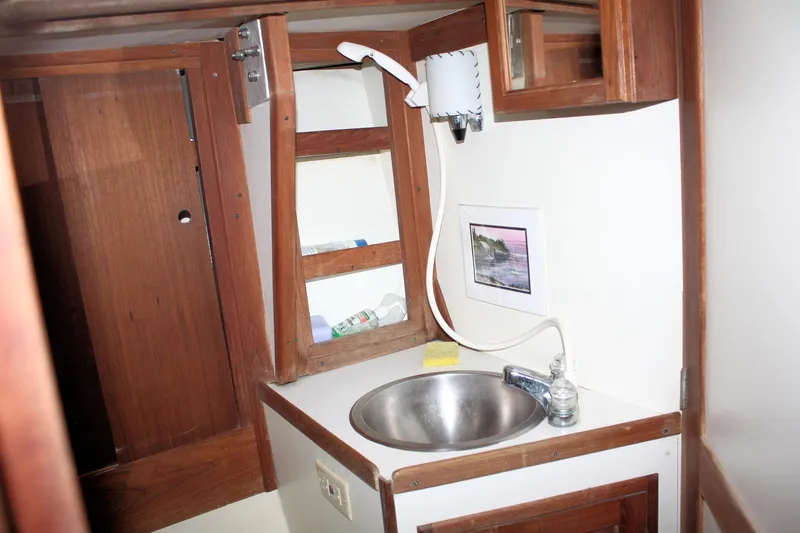 Slide: The Image of 1978 Tartan 37 sailboat bathroom with sink, wooden cabinets, and mirror. - 38