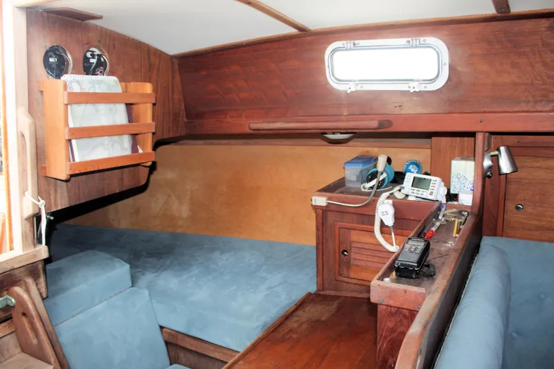 Slide: The Image of Interior of a 1978 Tartan 37 sailboat with wooden furnishings and blue seating. - 40