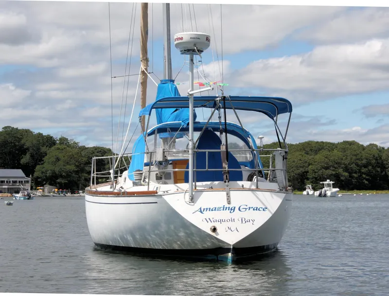 Slide: The Image of 1978 Tartan 37 sailboat named "Amazing Grace" anchored in a scenic bay. - 5