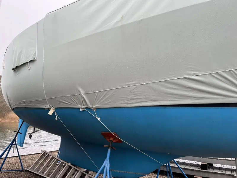 Slide: The Image of 1978 Tartan 37 sailboat with blue hull and protective cover on land. - 6