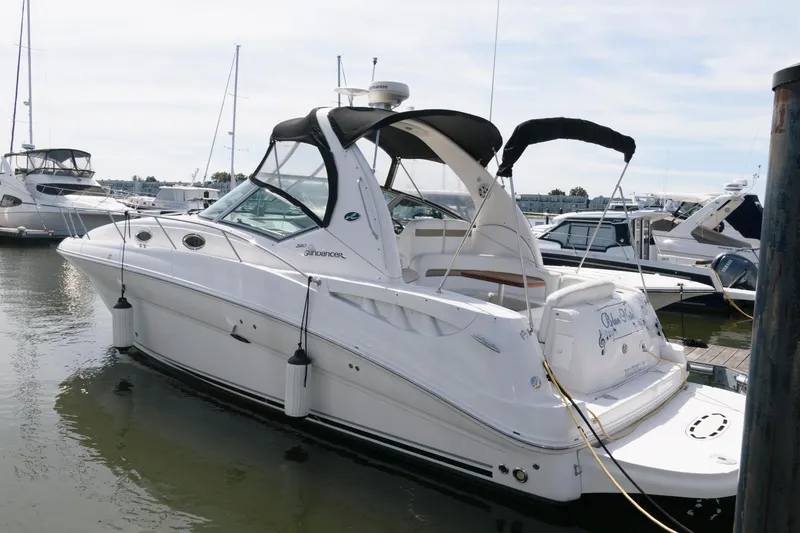 The Image of 2006 Sea Ray 320 Sundancer yacht docked at marina, featuring sleek design and canopy. - 0