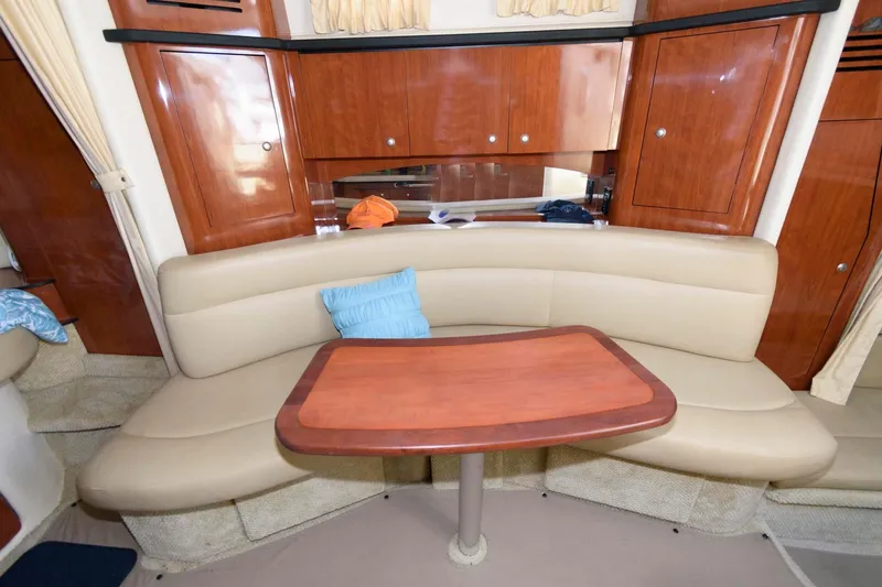 Slide: The Image of Interior of 2006 Sea Ray 320 Sundancer with beige seating and wooden table. - 12