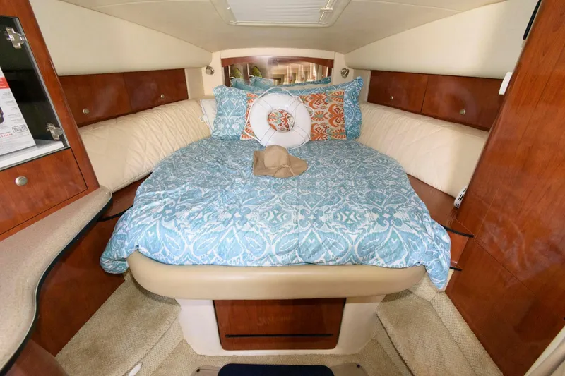 Slide: The Image of Cozy cabin interior of 2006 Sea Ray 320 Sundancer with patterned bedding and wood accents. - 14