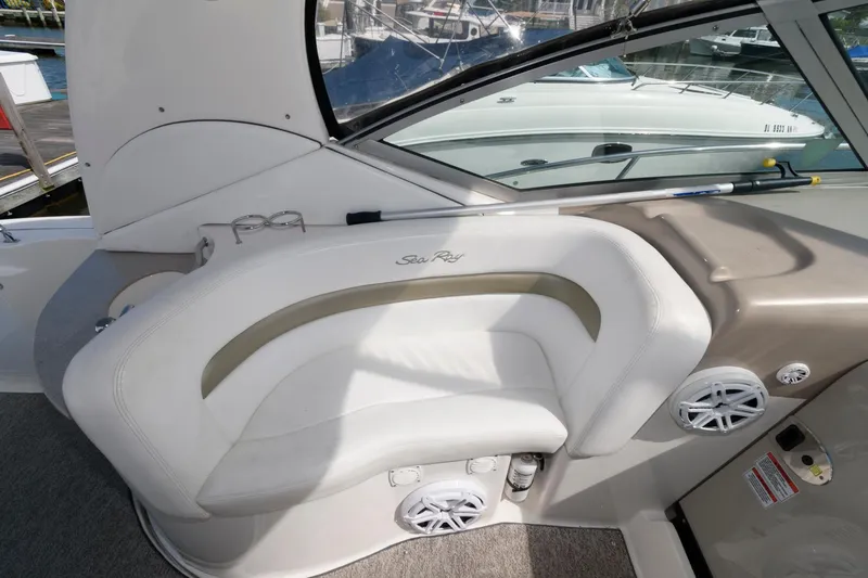 Slide: The Image of 2006 Sea Ray 320 Sundancer cockpit with white seating and speaker system. - 9