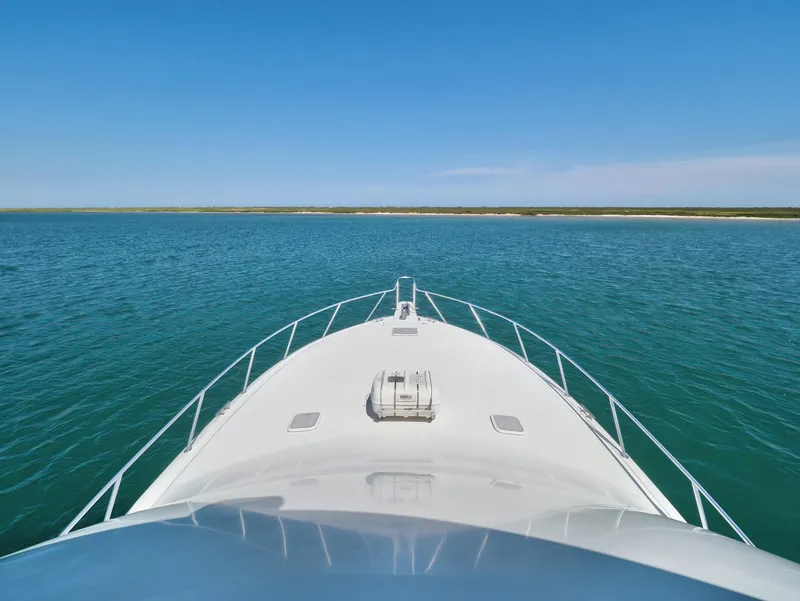 Slide: The Image of Bow view of 2007 Viking Convertible yacht on open water under clear blue sky. - 14
