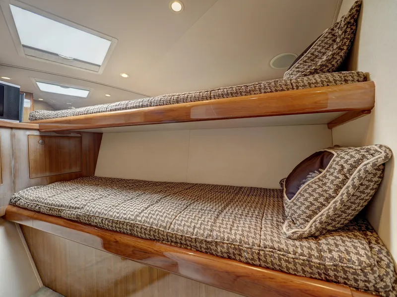 Slide: The Image of 2007 Viking Convertible yacht interior with mezzanine, featuring cozy bunk beds and elegant wood finish. - 33