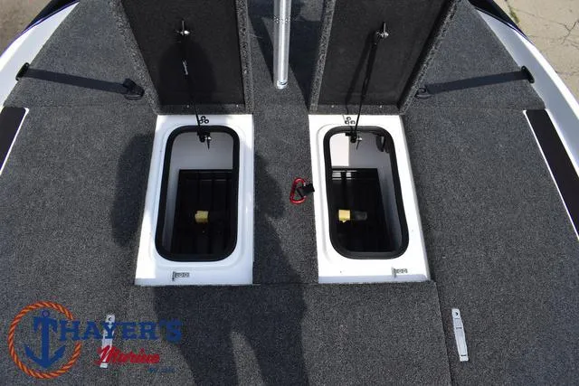 Slide: The Image of 2025 Bass Cat Puma STS boat storage compartments, open hatches, gray carpeted deck. - 20