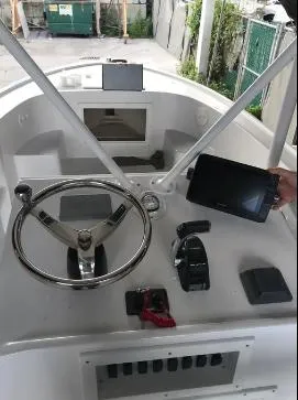 Slide: The Image of 1993 Mako 19 boat dashboard with steering wheel and electronic controls. - 3