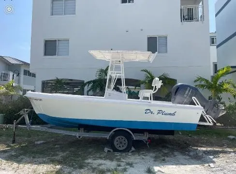 Slide: The Image of 1993 Mako 19 boat on trailer, parked near white building, palm trees in background. - 5