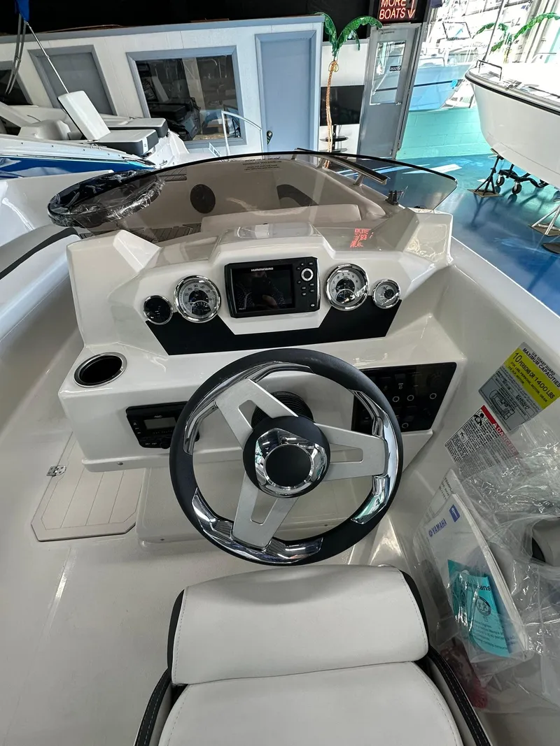 Slide: The Image of 2026 Starcraft SVX 171 OB boat interior with steering wheel and cushioned seating. - 14