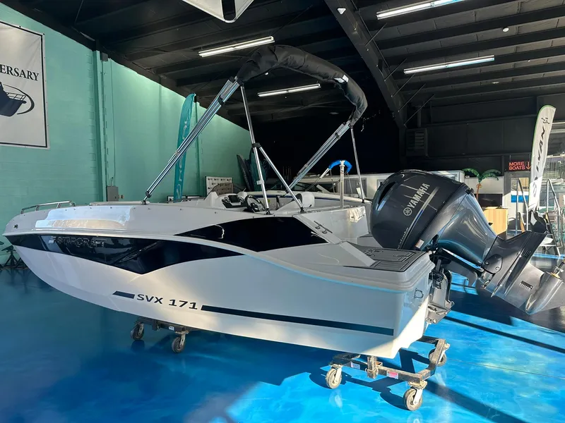 Slide: The Image of 2026 Starcraft SVX 171 OB boat with ladder on blue showroom floor. - 5