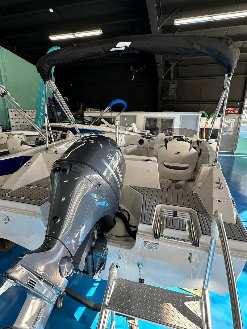 Slide: The Image of 2026 Starcraft SVX 171 OB boat with Yamaha outboard motor and boarding ladder on blue floor. - 8