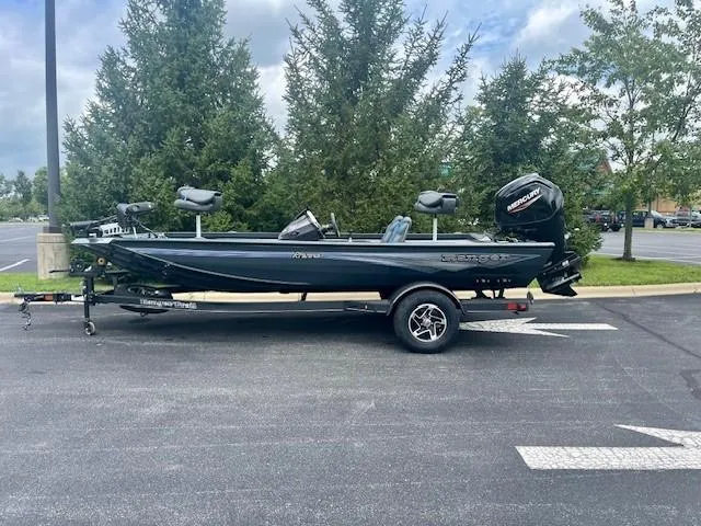 Slide: The Image of 2024 Ranger RT178 boat on trailer in parking lot, surrounded by trees. - 1