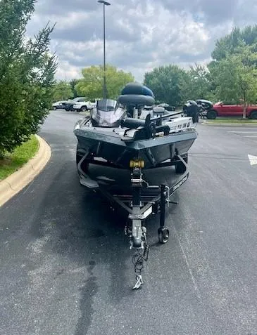 Slide: The Image of 2024 Ranger RT178 boat on trailer in parking lot, surrounded by trees. - 2