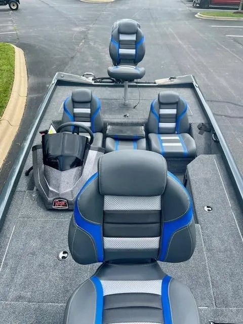 Slide: The Image of 2024 Ranger RT178 boat interior with blue and gray seating, steering console, and carpeted flooring. - 4