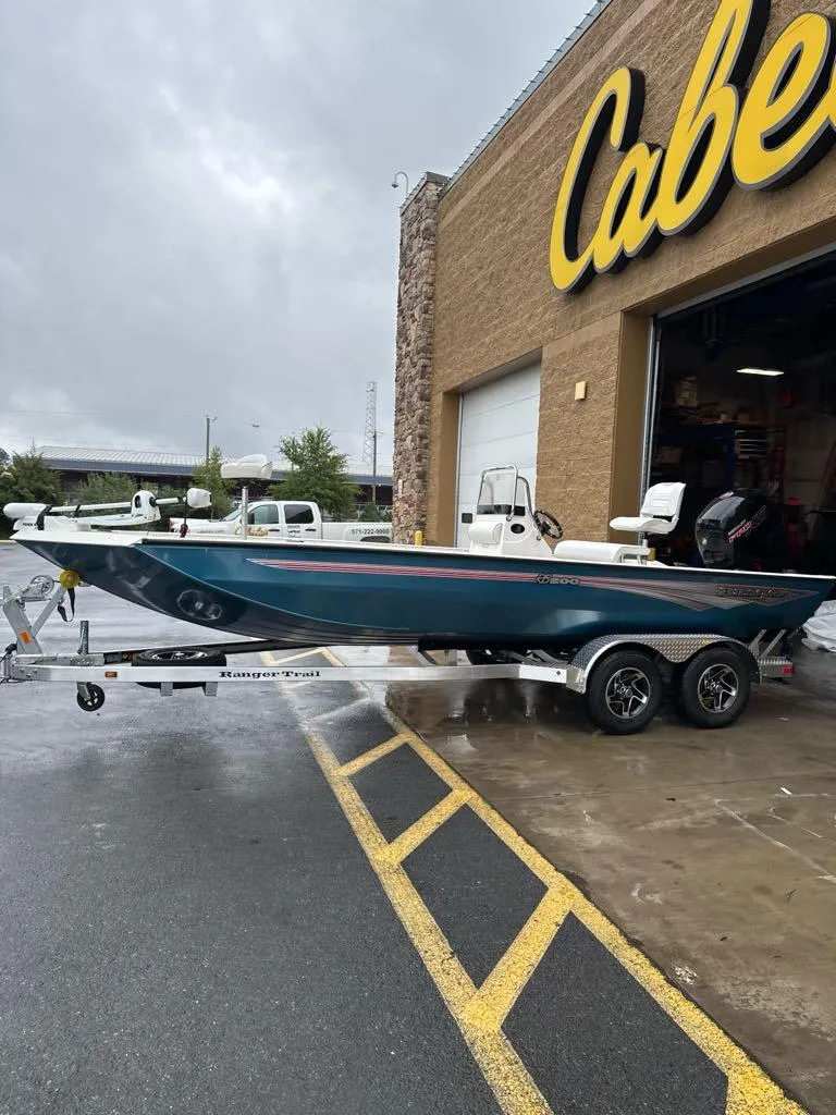 The Image of 2024 Ranger RB200 boat on trailer outside Cabela's store on a rainy day. - 0