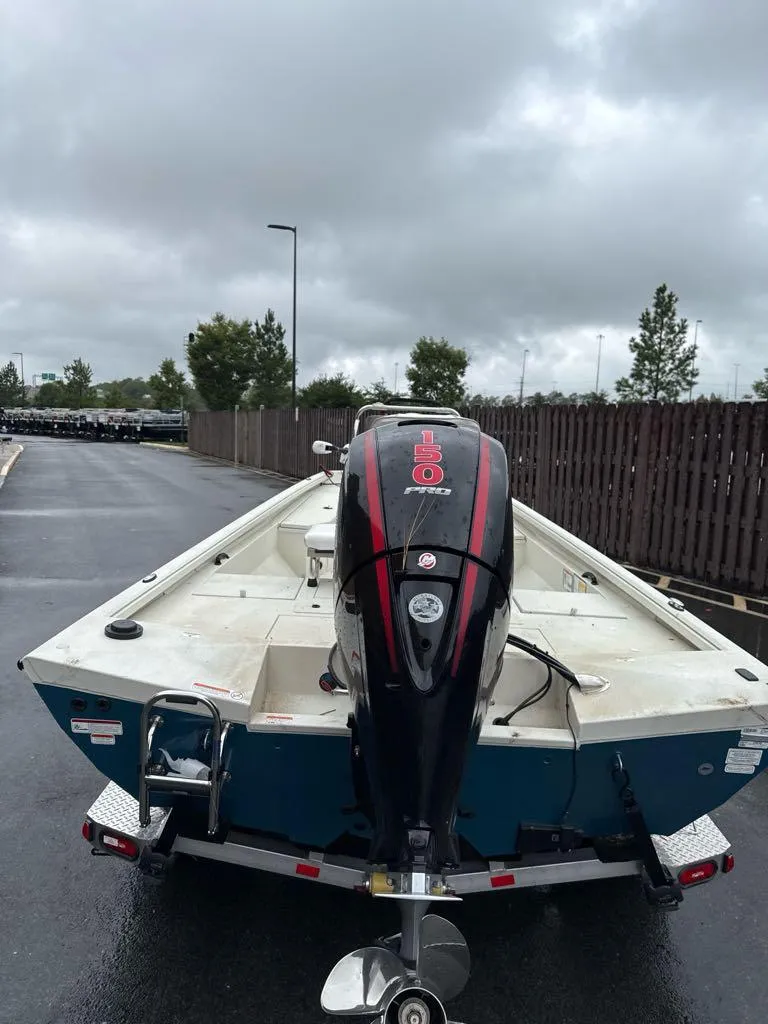 Slide: The Image of 2024 Ranger RB200 boat with outboard motor on a trailer, parked on a cloudy day. - 1