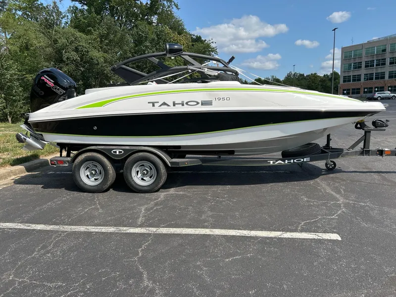 Slide: The Image of 2024 Tahoe 1950 boat on trailer in parking lot, sunny day. - 2